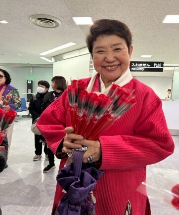 歓迎のバラの花束とともに